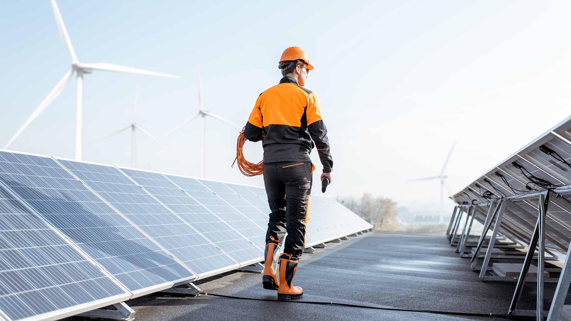 Tecnico che passeggia tra i pannelli di un impianto solare su un tetto